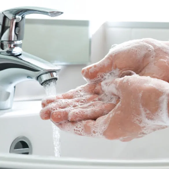 a pair of hands being washed with soap and water